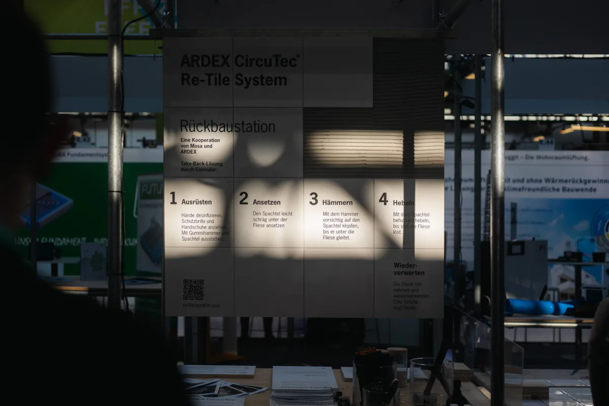 Infotafel der Ardex CircuTec Re-Tile Rückbaustation auf dem Klimafestival mit Schritt-für-Schritt-Anleitung zum zirkulären Fliesenrückbau in Kooperation mit Mosa