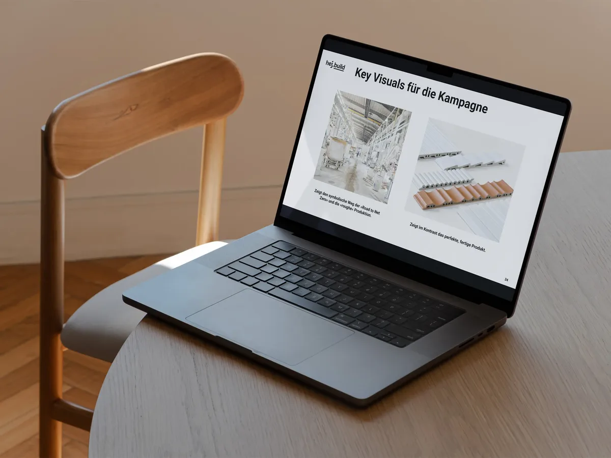 Laptop auf Holztisch zeigt eine Präsentation der Key Visuals für die Road-to-Net-Zero-Kampagne von AGROB BUCHTAL, mit Produktionsfotos und Produktabbildungen keramischer Fliesen