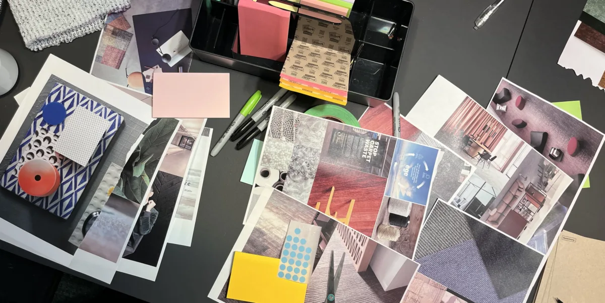 Arbeitstisch mit Moodboard-Materialien: Teppichmuster, Farbkarten, Magazinausschnitte und Post-its auf dunkler Arbeitsfläche.