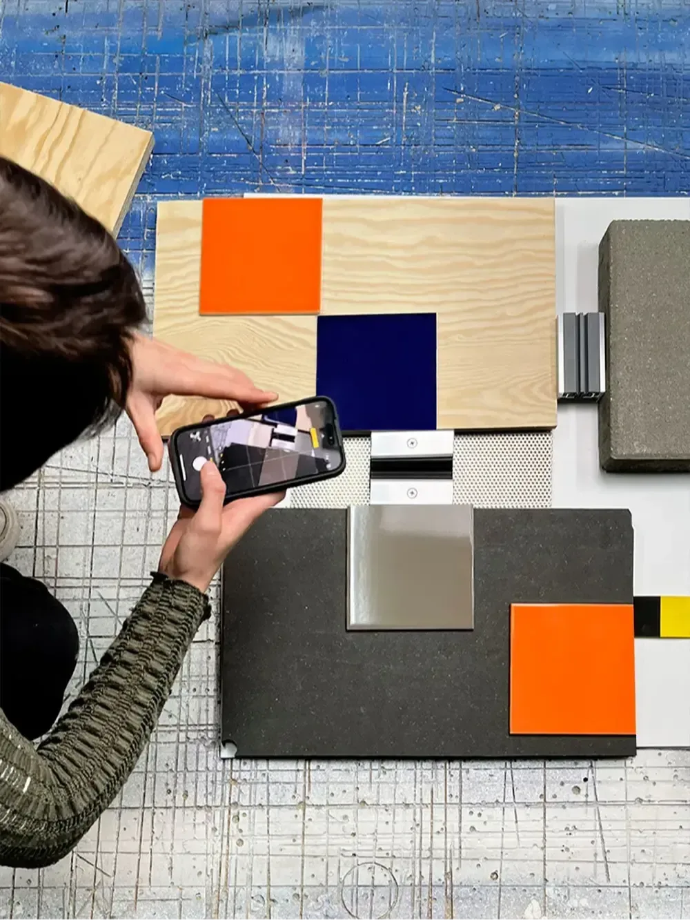 Ein Team Member von hej.build filmt mit einem Smartphone Produkte von Bauprodukthersteller:innen.